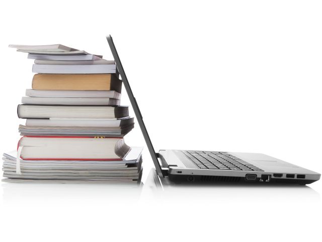 Open laptop screen leaning against a stack of books